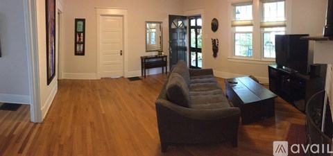 A living room with a grey couch and a wooden floor.