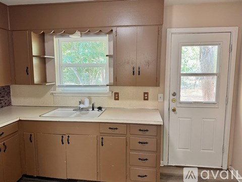 A kitchen with brown cabinets and a white sink.