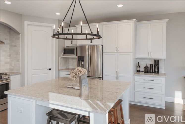 A kitchen with a marble countertop and a chandelier hanging from the ceiling.