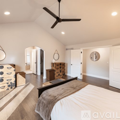 A white closet with clothes hanging on hangers.