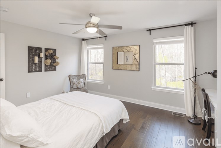 A bedroom with a large bed and a ceiling fan.