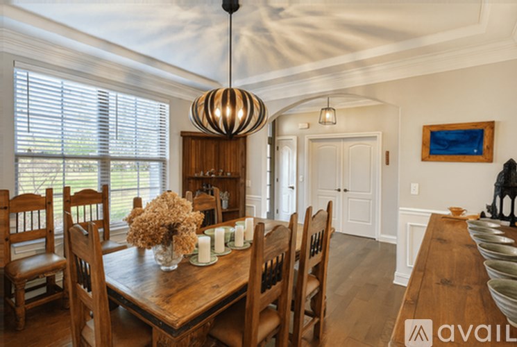 A dining room with a wooden table and chairs.