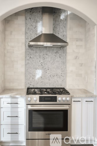 A modern kitchen with a stove top oven and a range hood.