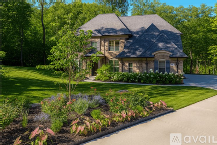 A dog is sitting in the grass in a yard.