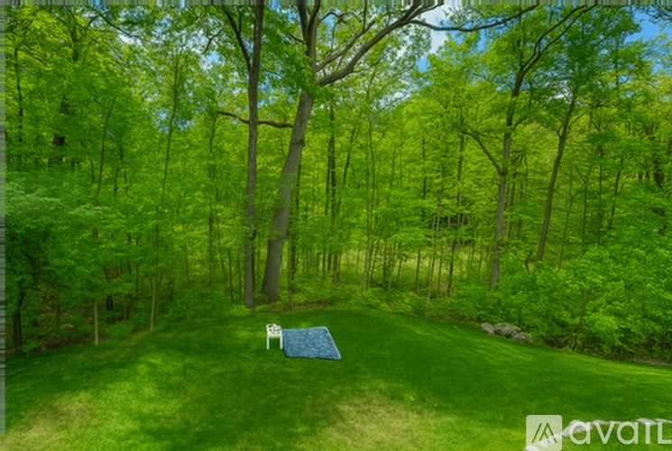 A row of white hydrangeas in front of a brick house.