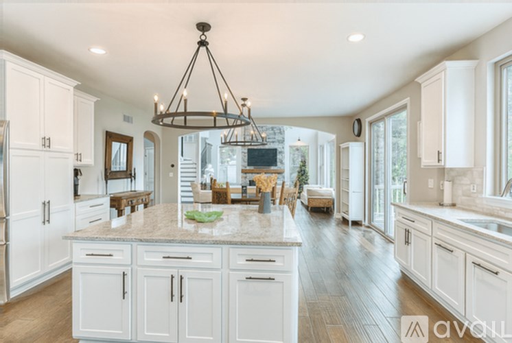 A large, well-lit kitchen with white cabinets and a central island.