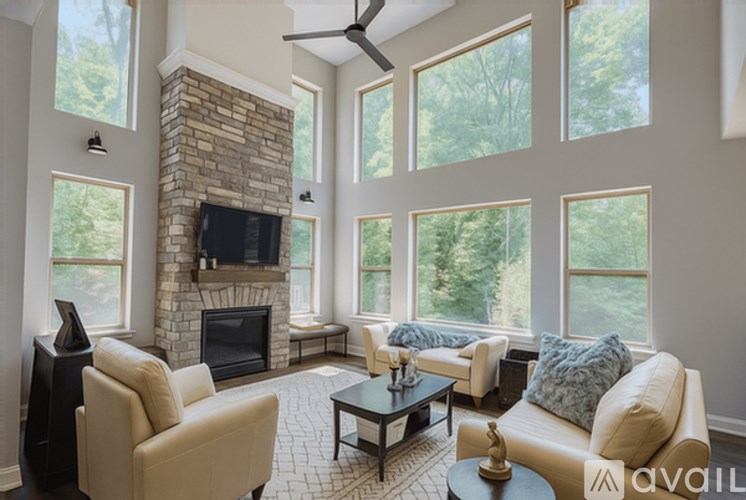 A living room with a stone fireplace and a balcony.