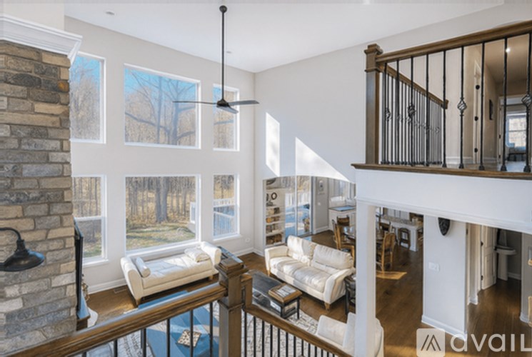 A living room with a white couch, a fireplace, and a TV.