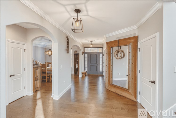 A hallway with a wooden floor and white walls.