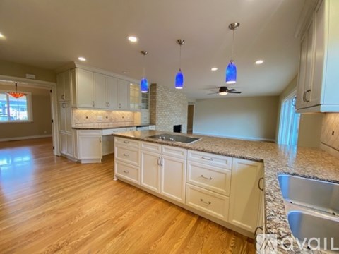 A kitchen with white cabinets and a marble countertop.