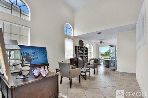 A living room with a painting on the wall and a bookshelf.