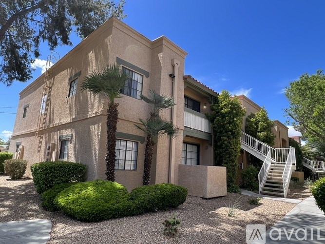 A beige house with a palm tree in front.