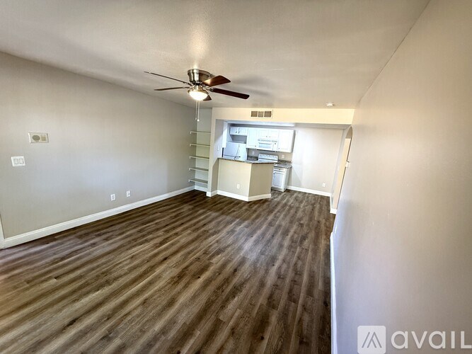 A room with a ceiling fan and wooden flooring.