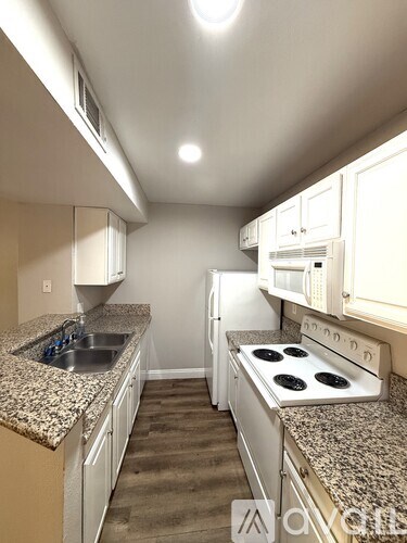 A kitchen with granite countertops and white cabinets.