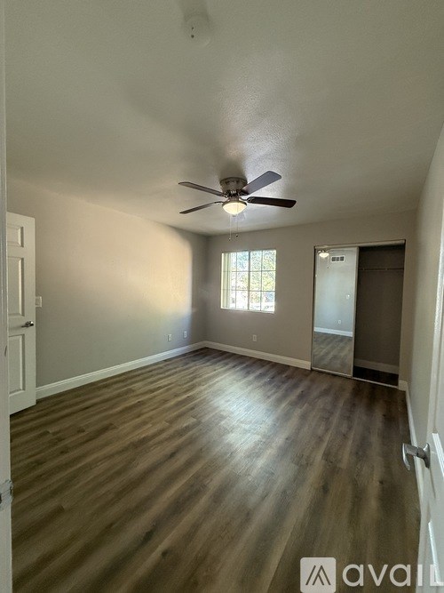 A room with wooden flooring and a ceiling fan.