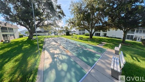 A sunny day at the park with a playground and benches.