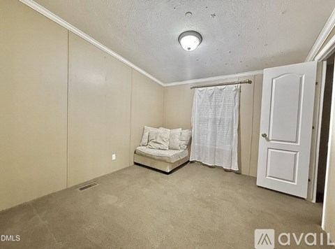 A living room with a couch and a window with curtains.