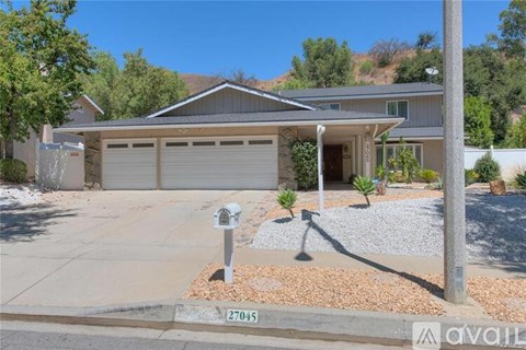 A house with a garage and a driveway in front of it.