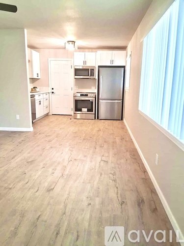 A kitchen with wooden floors and stainless steel appliances.
