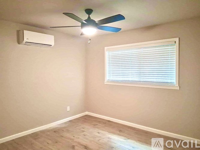 A room with a ceiling fan and a window with blinds.