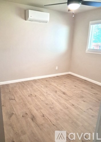 A room with a ceiling fan and a door with a black handle.
