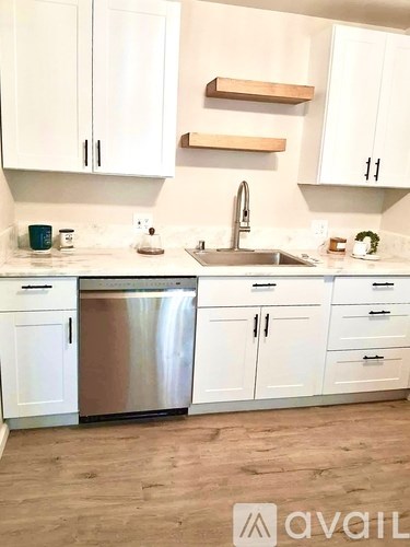 A kitchen with white cabinets and a stainless steel dishwasher.