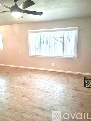 A room with a ceiling fan and a window.