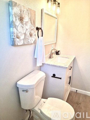 A white toilet sits next to a bathtub in a bathroom with marble walls.