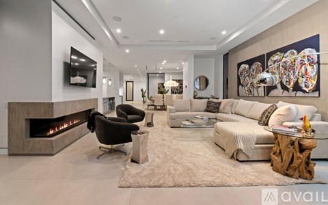 A modern living room with a fireplace and a large painting on the wall.