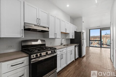 A kitchen with white cabinets and a black stove top oven.