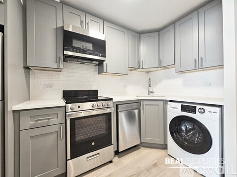 A modern kitchen with a washing machine and a dishwasher.