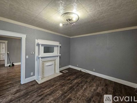 A room with a fireplace and a broom is available for rent.