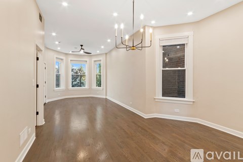 A room with wooden floors and a chandelier hanging from the ceiling.