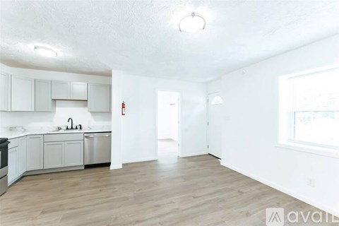 A kitchen with white cabinets and a wooden floor.