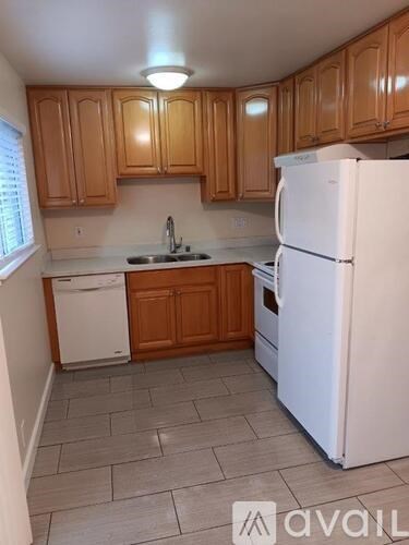 A kitchen with wooden cabinets and a white refrigerator.