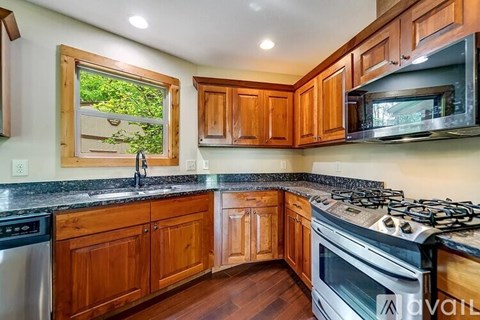 A kitchen with wooden cabinets and a window.
