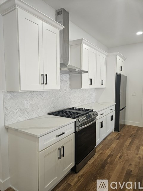 A kitchen with white cabinets and a black stove top oven.
