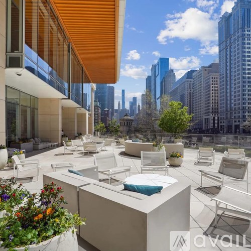 A rooftop patio with white furniture and a view of the city.