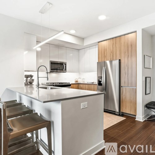 A modern kitchen with a stainless steel refrigerator and wooden accents.