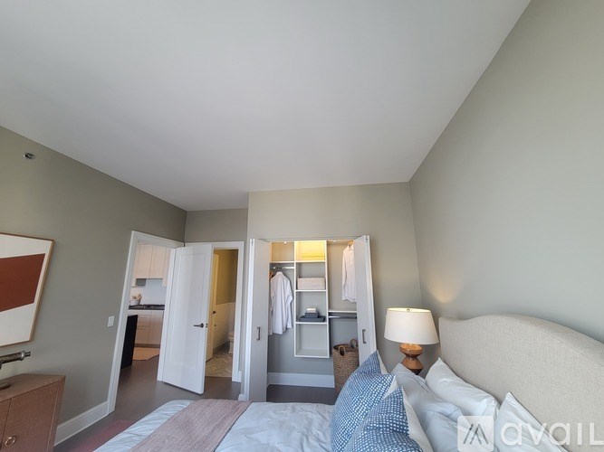 A bedroom with a bed, a nightstand, and a mirror.