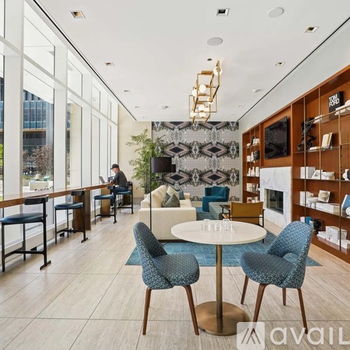 A modern living room with a white table and blue chairs.