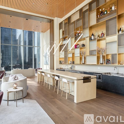 A modern kitchen with a bar area and a staircase leading to the upper floor.