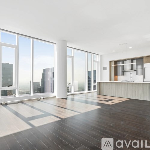 A spacious, modern kitchen with wooden floors and a large window overlooking the city.