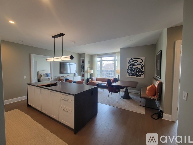 A modern kitchen with white cabinets and a black island.