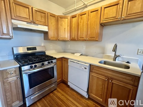 A kitchen with wooden cabinets and a stainless steel stove.