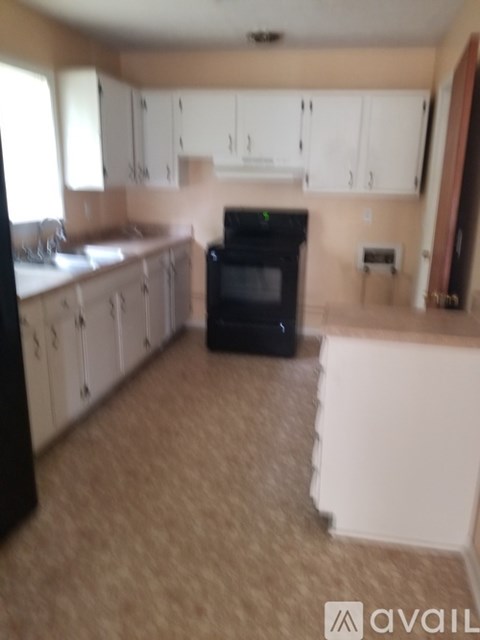 A kitchen with a black oven and white cabinets.