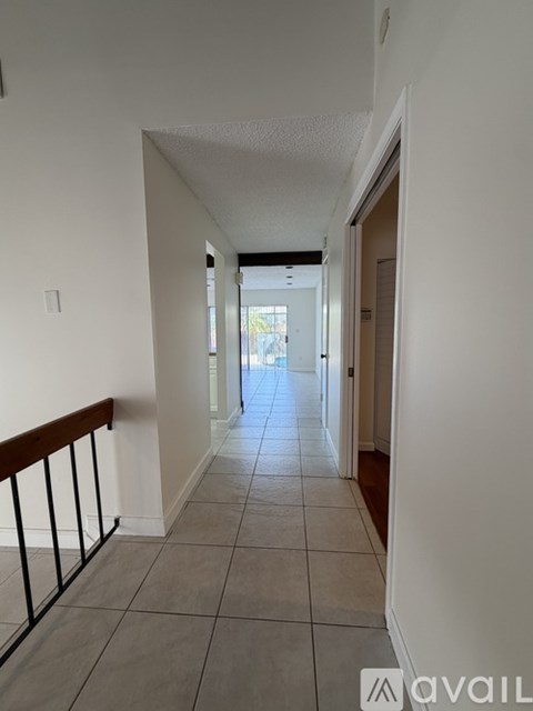A long hallway with tiled floors and white walls.