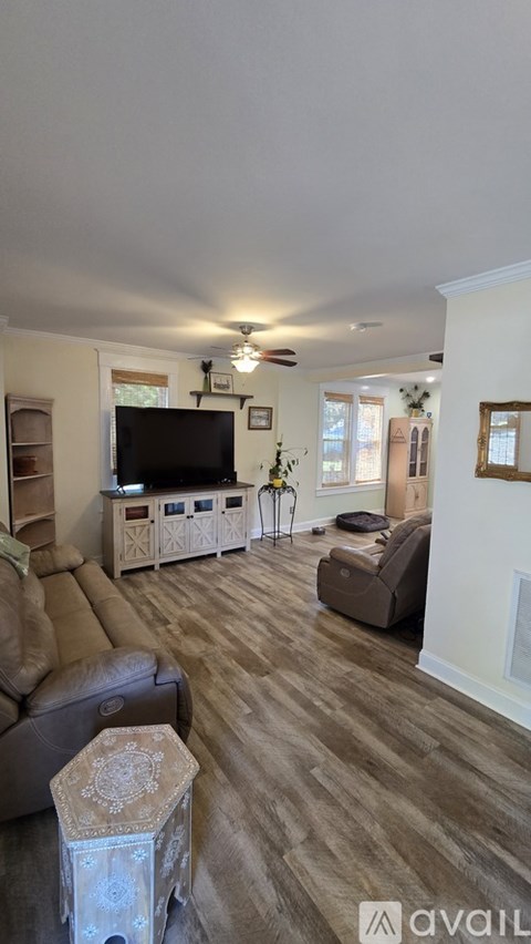 A living room with a brown sofa and a television.