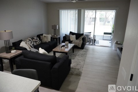 A living room with a black couch and a white table.
