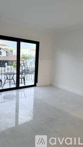 A room with a sliding glass door leading to a balcony.